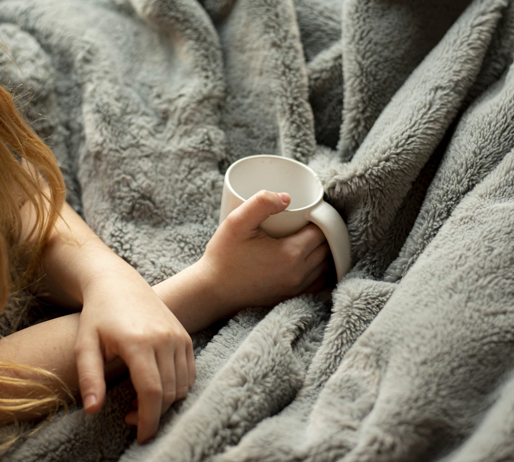 Frau hält eine warme Tasse in den Händen