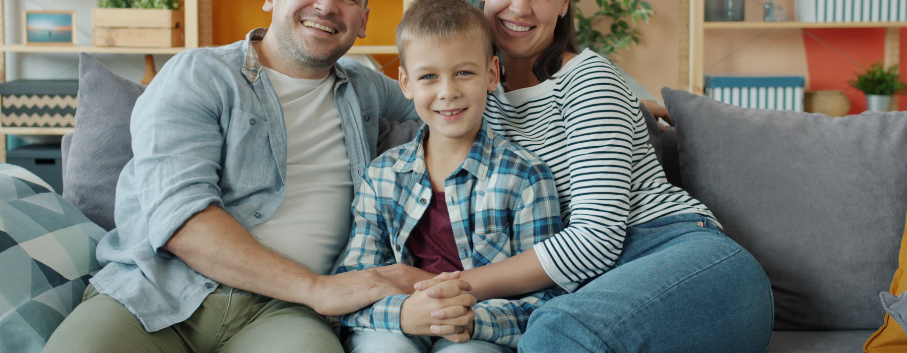 Fröhliche Familie sitzt zu Hause auf dem Sofa